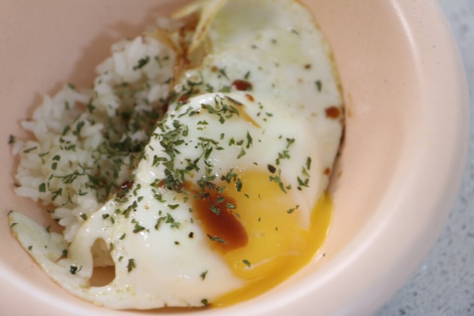cooked eggs over rice with soy sauce